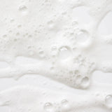 Zoom sur la mousse fine et aérienne du savon liquide Fleur d'Oranger, avec des bulles blanches sur fond clair